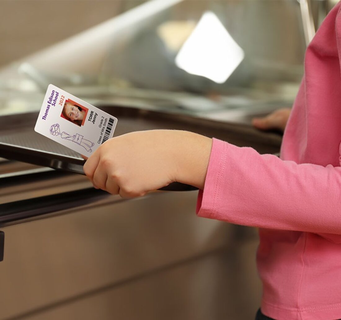 child holding his tray and his personalized lunch card thanks to the Badgy printer