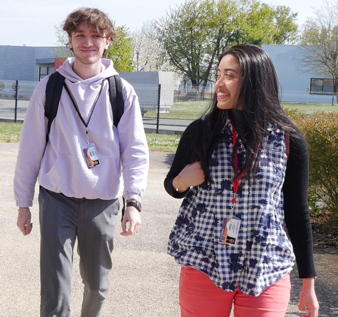 Two students walking to school with their ID cards around their necks