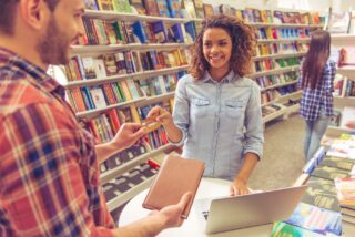 Beautiful,Afro,American,Girl,Is,Smiling,While,Buying,Book,At